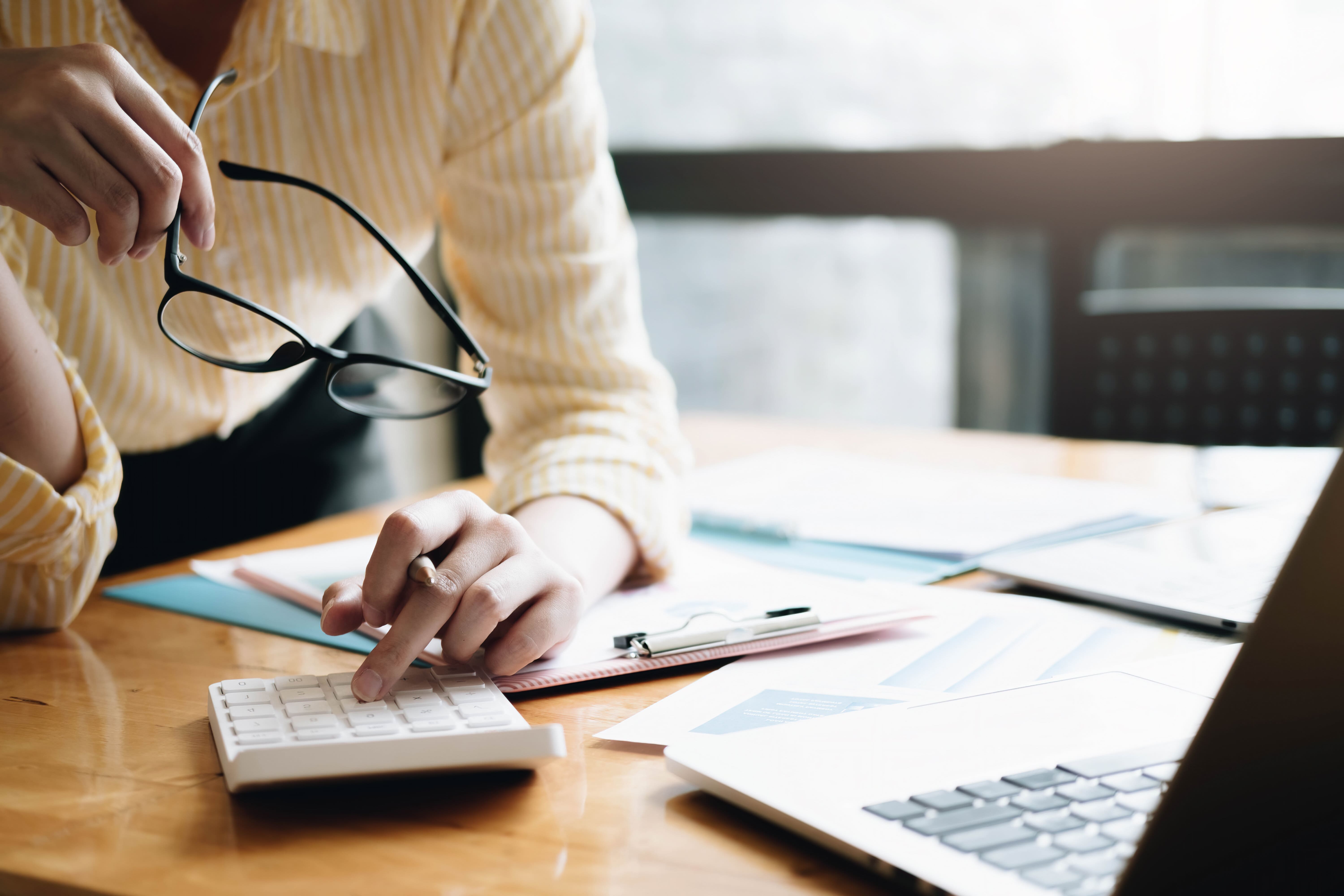vecteezy_close-up-business-woman-using-calculator-and-laptop-for-do__812--1-