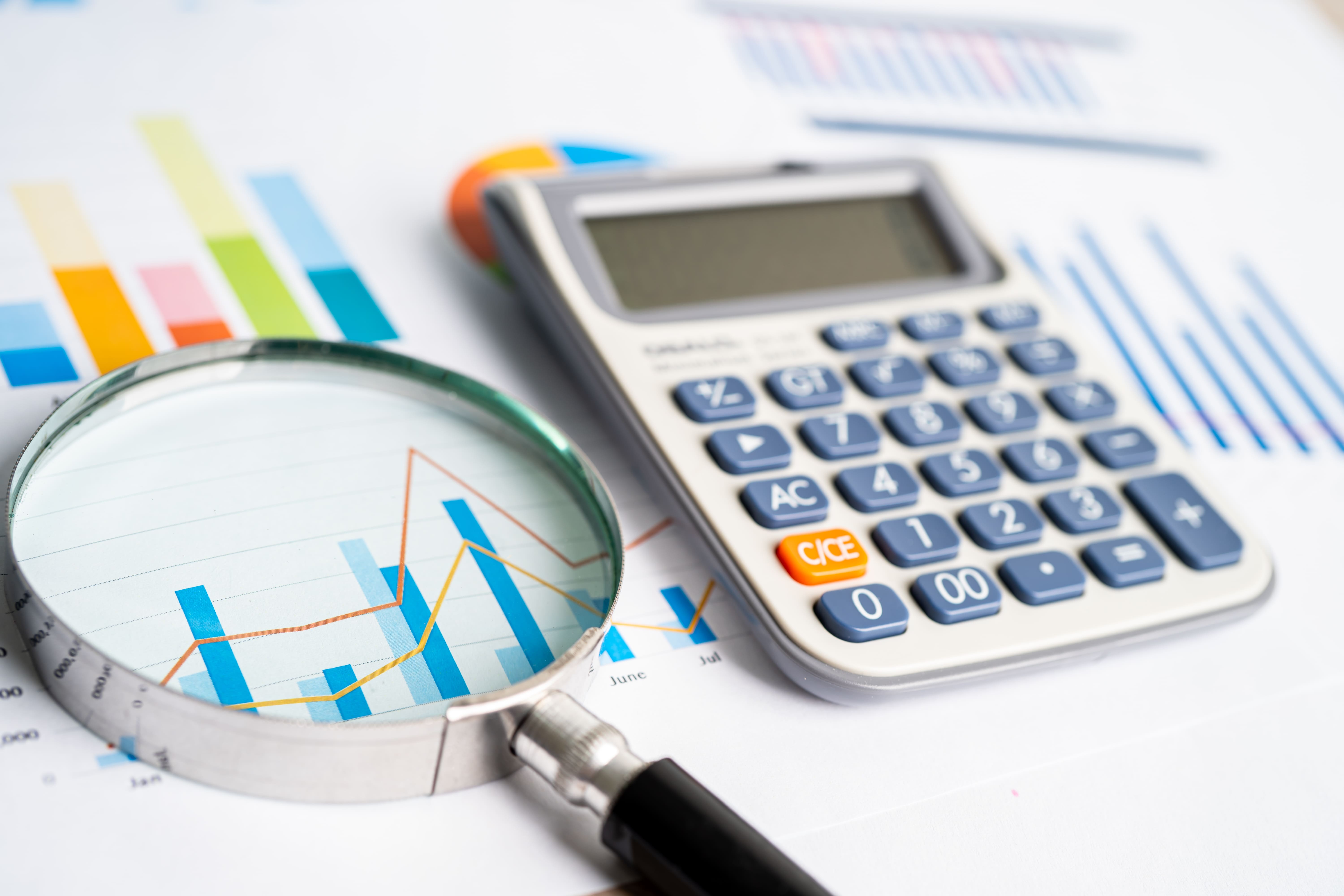 vecteezy_magnifying-glass-and-calculator-on-charts-graphs-paper_6913948_413--1-